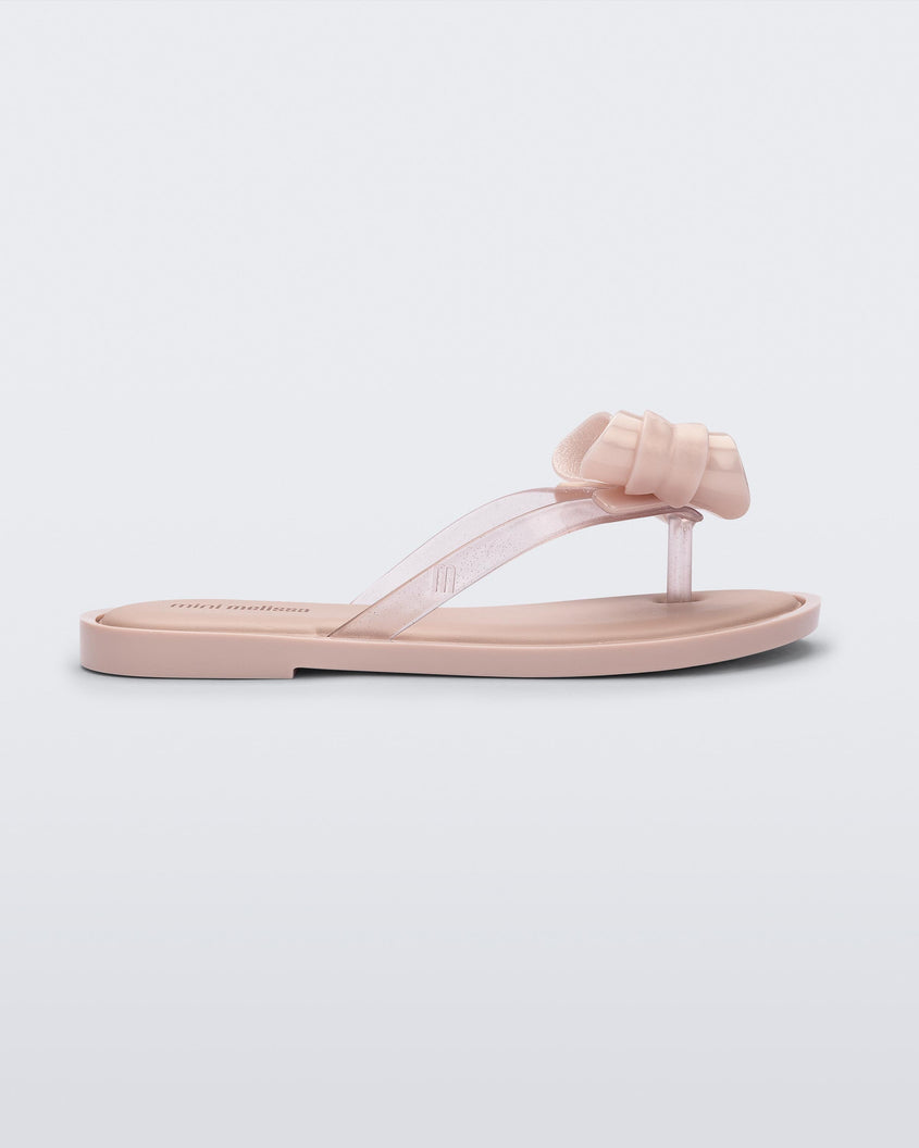 Side view of a Mini Melissa Flip Flop in pink with bow applique