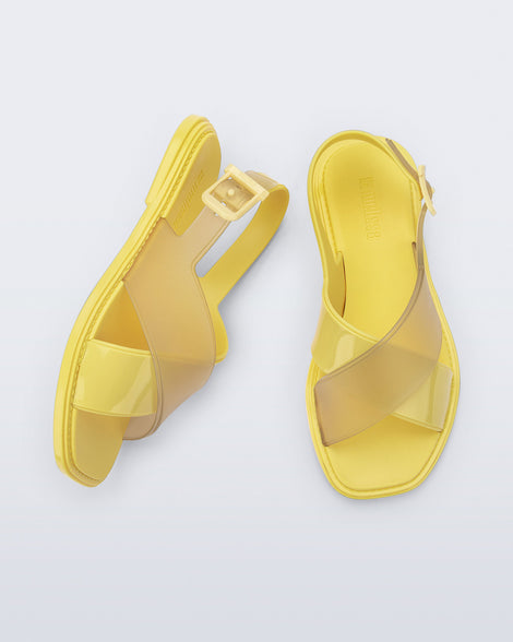 Top and side view of a pair of yellow Cleo sandals with back strap and crisscross top straps