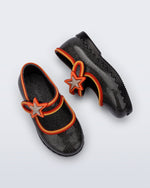 Side and top view of a pair of glitter black Hip Ballerina Star baby flats with star on upper strap