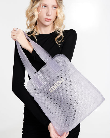 Model in a black outfit with a clear Harper bag in her hand