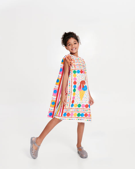 Child model in a multi colored dress wearing a pair of glitter/clear/silver Possession kids fisherman sandals