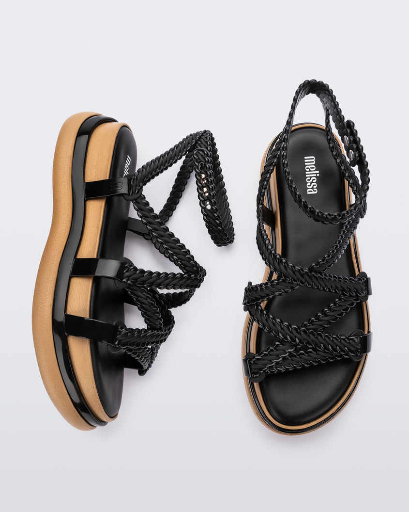 A top and side view of a pair of black Melissa Buzios platform sandals with multiple textured straps that mimic sisal braids across the front of the shoe as well as an ankle strap