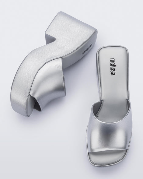 Top and side view of a pair of Melissa Posh platform slides in Silver