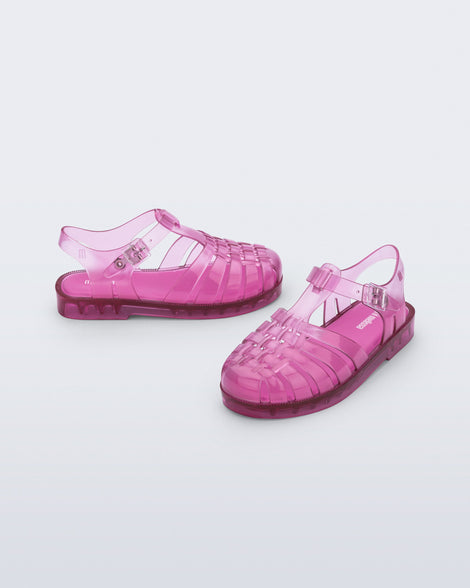 Side and angled view of a pair of transparent pink Possession fisherman kids sandals