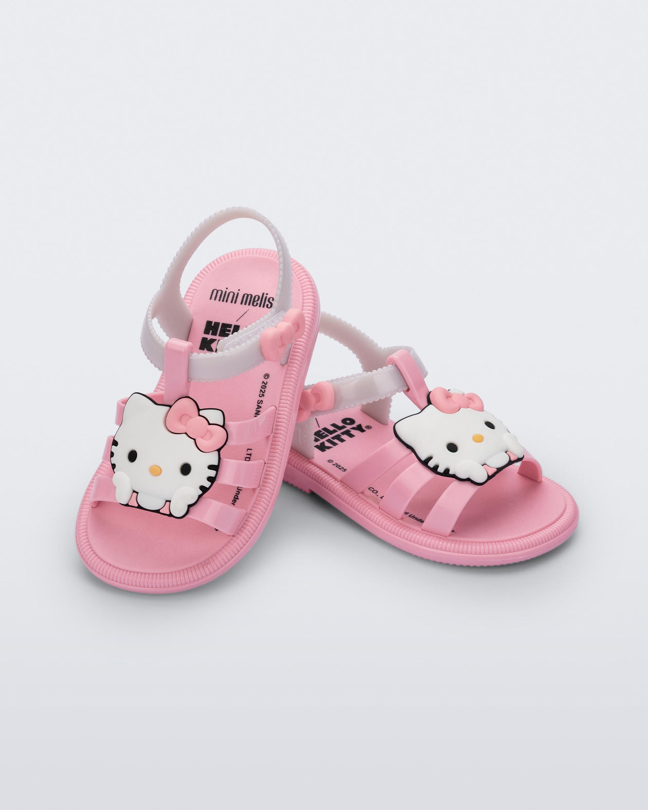 Angled view of a pair of pink Hip + Hello Kitty and Friends sandals with white ankle straps and Hello Kitty on upper