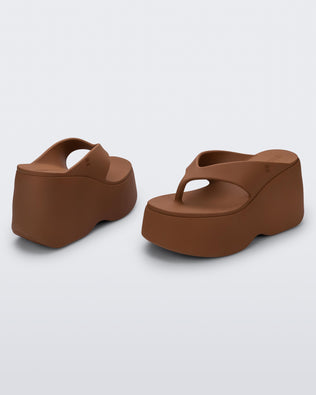 Back and side angled view of a pair of brown Free Thong Wedge platform flip flop sandals