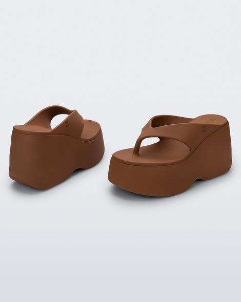 Back and side angled view of a pair of brown Free Thong Wedge platform flip flop sandals