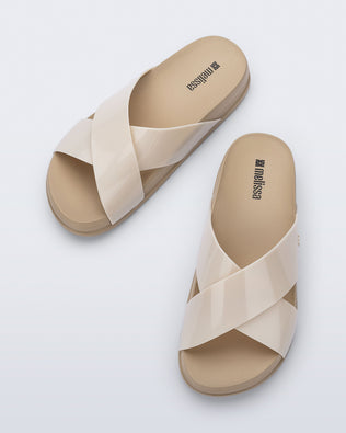 Top view of a pair of beige Cozy Cross sandals with crisscross top straps