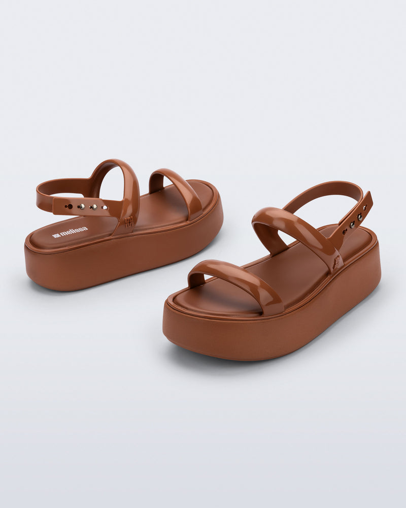 Back and angled view of a pair of brown Wave Platform sandals with top and heel straps