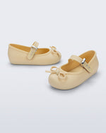 Side and angled view of a pair of yellow Soft Ballerina Delicate Bow baby flats with top strap and bow
