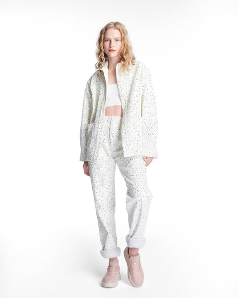 Model in white pant set wearing a pair of pink X Mood sneakers