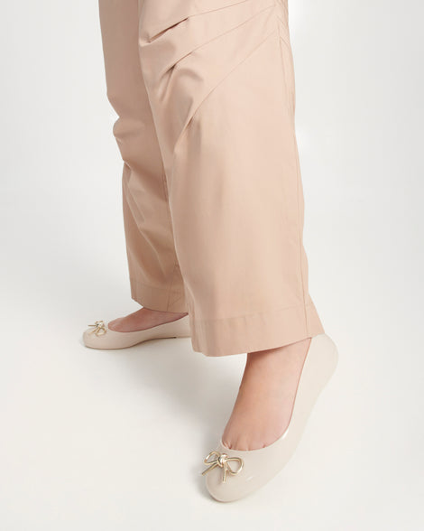 Model's legs wearing a pair of beige Sweet Love Chrome flats with gold bow