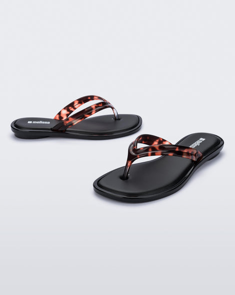 Side and angled view of a pair of tortoise Wave Flip Flops with small heel and black sole