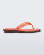 Side view of a orange Wave Flip Flop with small heel and brown sole