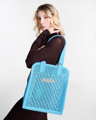 Model in a black outfit with a blue Harper bag on her shoulder
