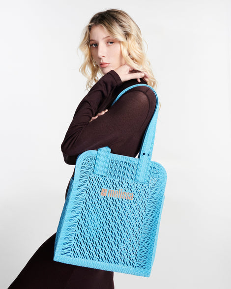 Model in a black outfit with a blue Harper bag on her shoulder