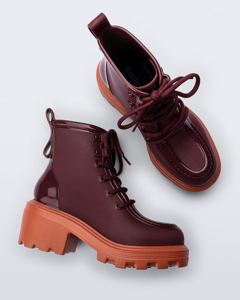 Top and side view of a pair of burgundy Track Boot with small heel and burgundy laces and orange sole
