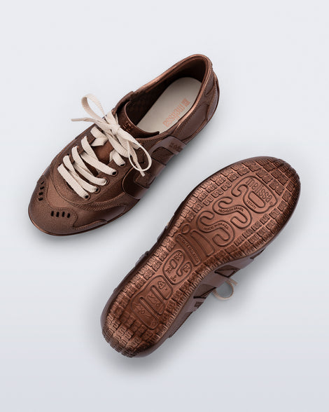 Top and bottom view of a pair of bronze Motion sneakers with beige laces