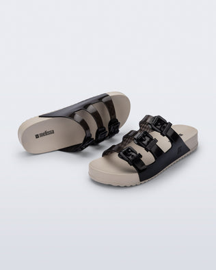 Top and angled view of a pair of beige Cozy Stripes sandals with black upper with 3 buckles