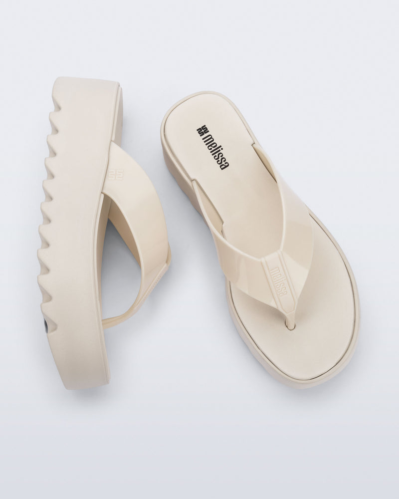 Angled and top view of a pair of beige Thong Platform flip flops
