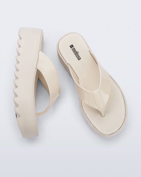 Angled and top view of a pair of beige Thong Platform flip flops