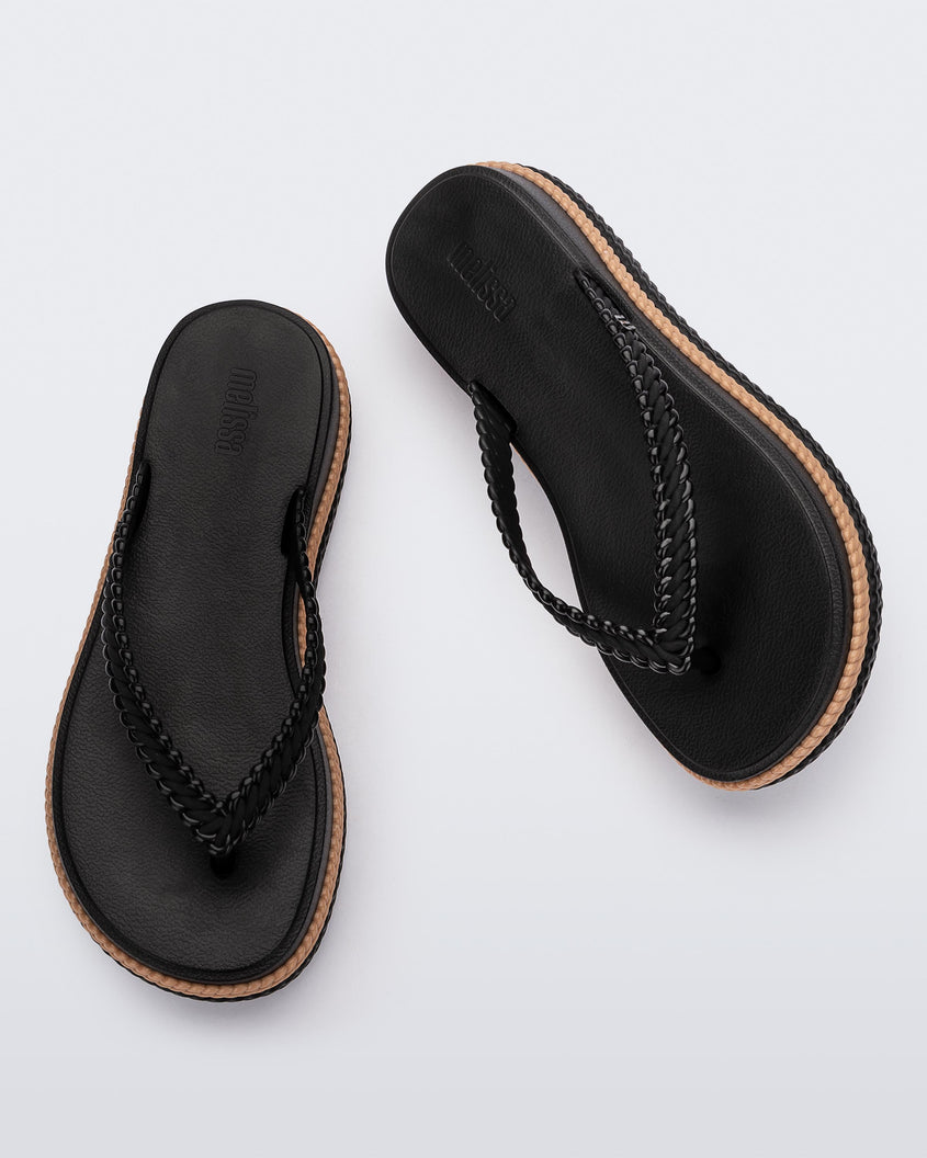 Top view of a pair of black/beige Melissa Leblon platform flip flops with details that mimic sisal braids on the sole and strap