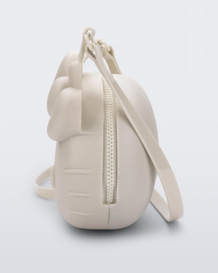 Side view of a beige Hello Kitty + Friends Cute Bag with the face of Hello Kitty