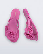 Top and side view of a pair of pink Harmonic Petals kids flip flops with flowers