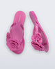 Top and side view of a pair of pink Harmonic Petals kids flip flops with flowers