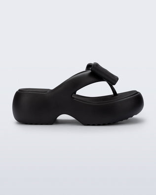 Side view of a black Free Fuzzy Platform flip flop 