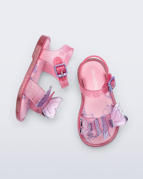 Top and side view of a pair of glitter pink baby Butterfly sandals with pink butterflies
