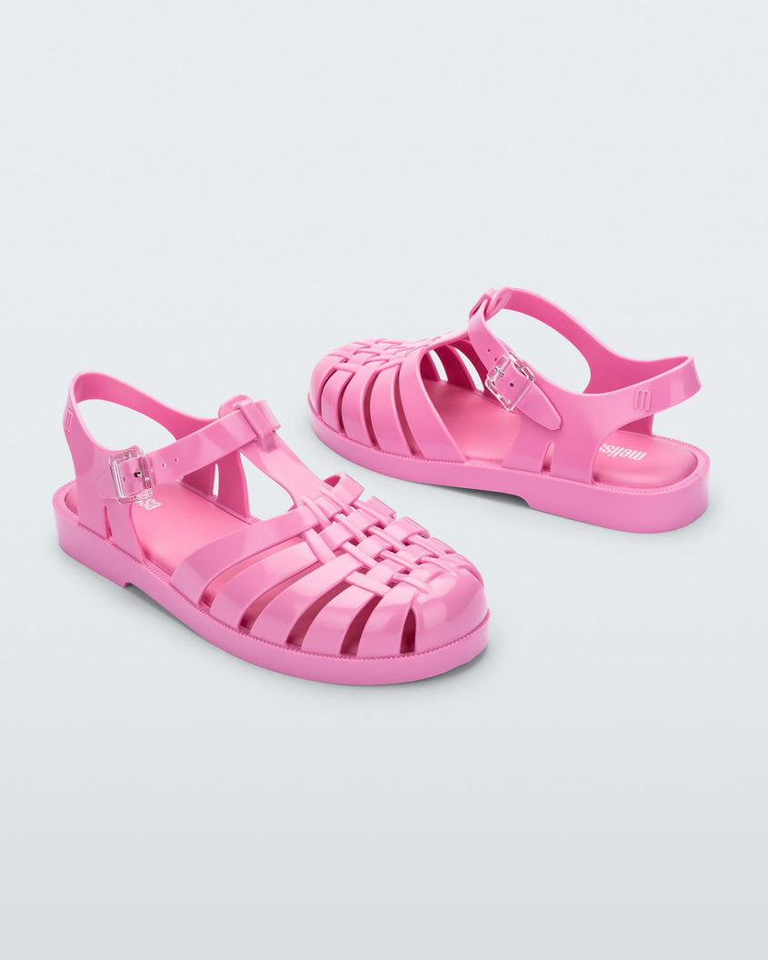 An angled front and back view of a pair of pink Melissa Possession sandals with a fisherman sandal design