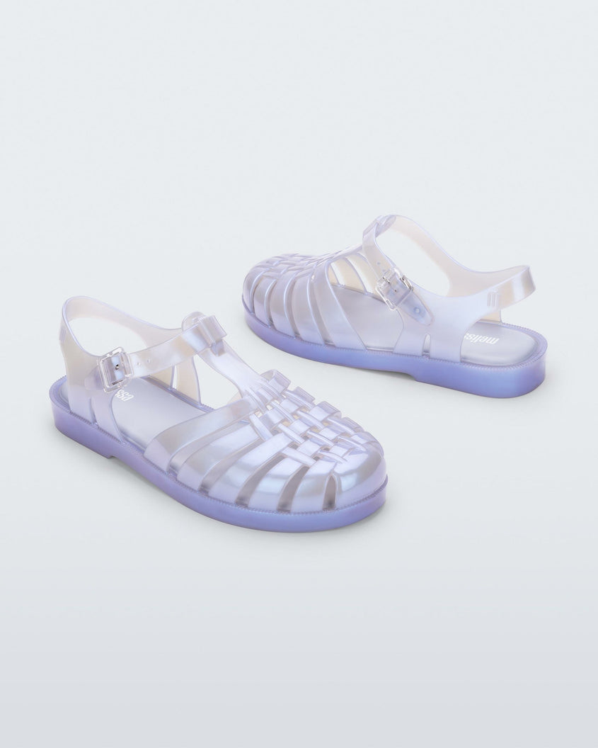 An angled side and back view of a pair of pearly blue Melissa Possession sandals with a fisherman sandal design