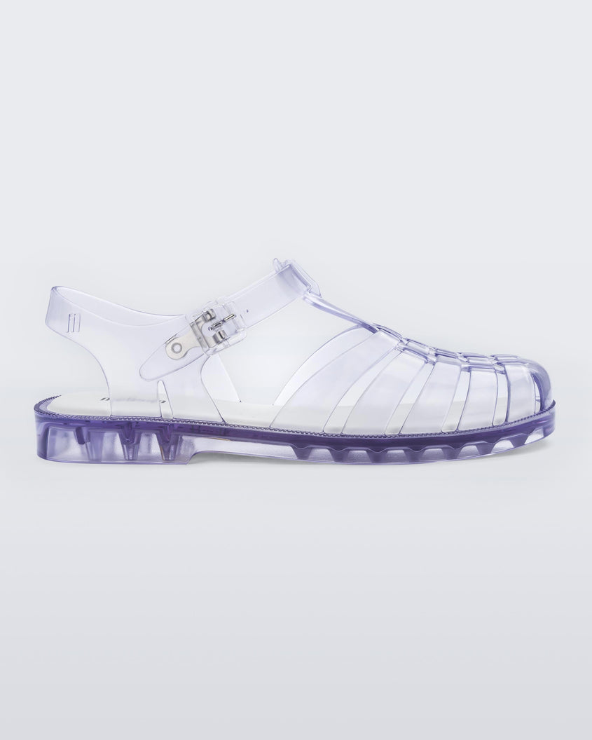 Side view of a pair of clear Melissa Possession sandal with a closed toe front weft design connected to a top strap with a buckle.