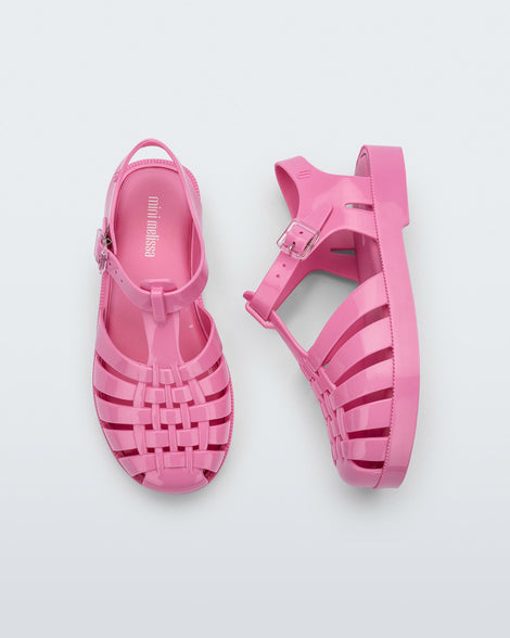 A top and side view of a pair of pink Mini Melissa Possession sandals with a fisherman sandal design