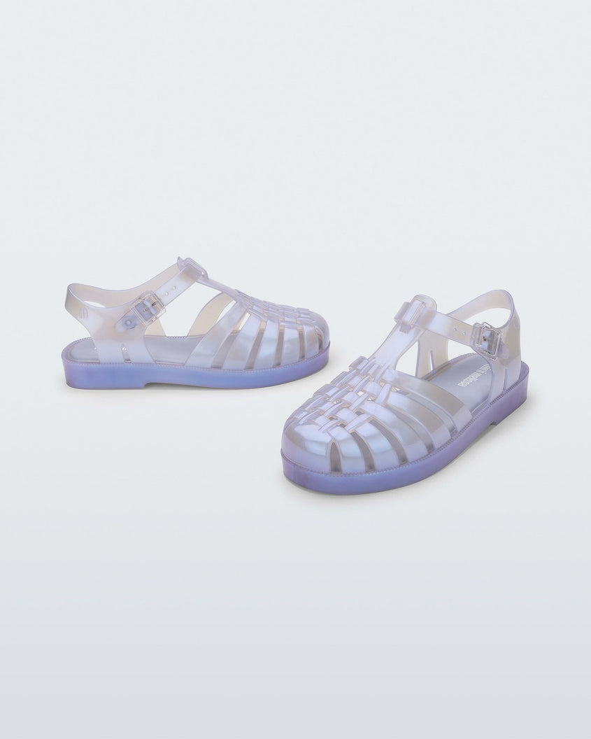 An angled front and side view of a pair of pearly blue Mini Melissa Possession sandals with a fisherman sandal design