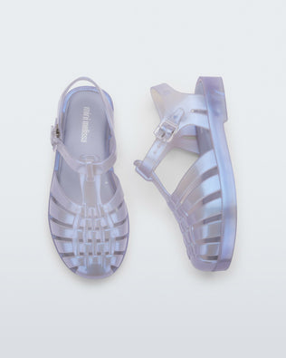 A top and side view of a pair of pearly blue Mini Melissa Possession sandals with a fisherman sandal design