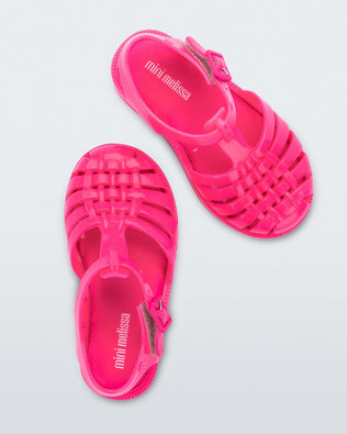 Top view of a pair of pink Mini Melissa Possession sandals with several straps and a closed toe front.