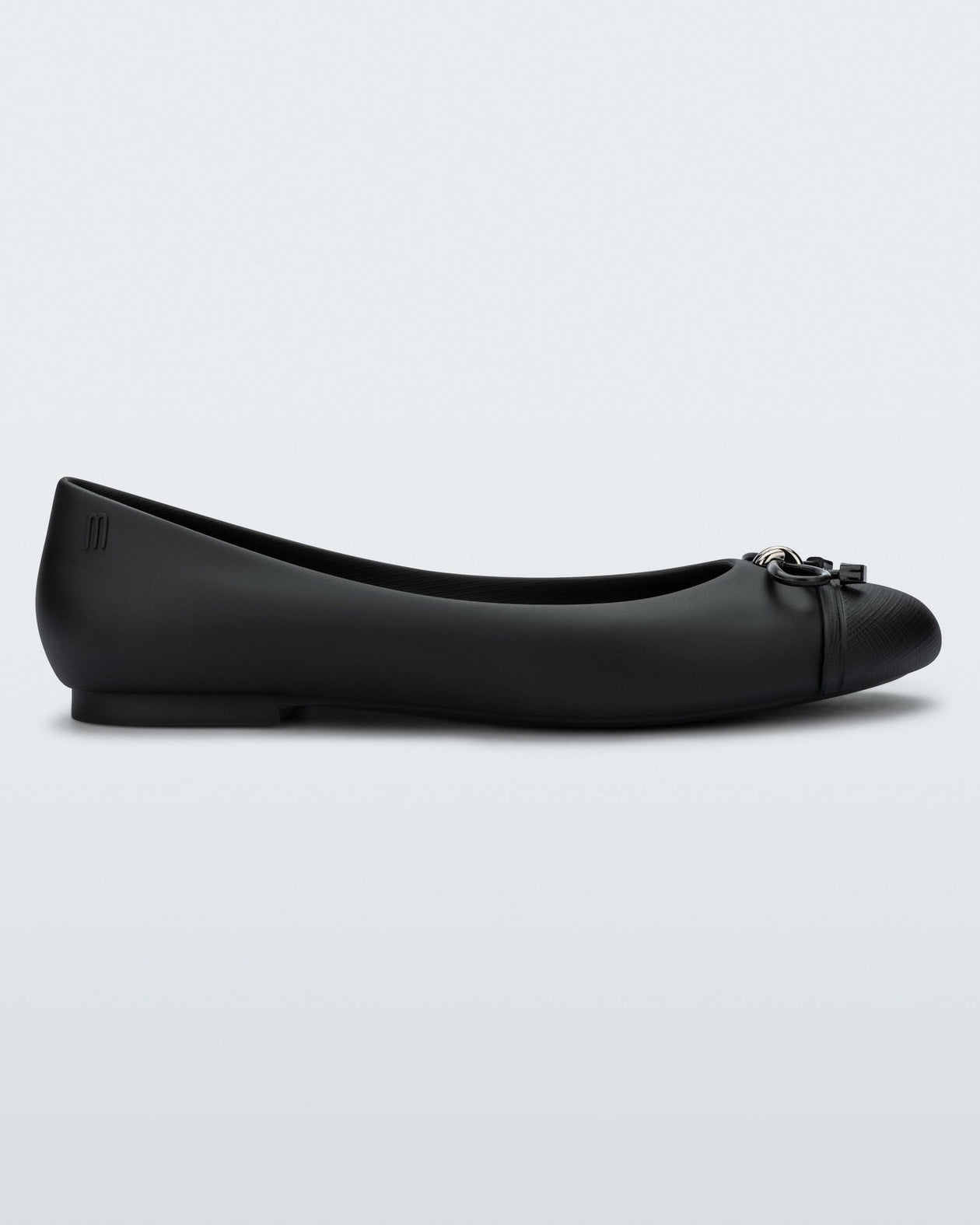 Side view of a black Melissa flat with a black bow detail with metallic accents on the toe