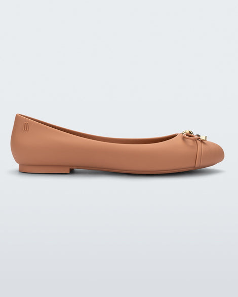 Side view of a dark beige Melissa flat with a beige bow detail with gold accents on the bow