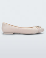Side view of a light beige Melissa flat with a beige bow detail with gold accents on the toe