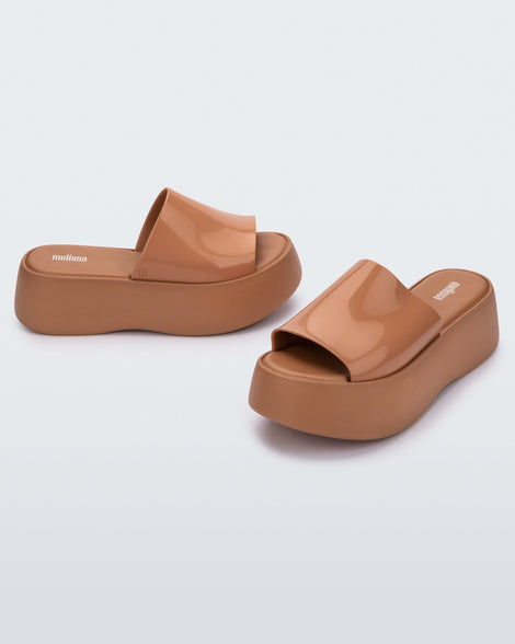 Alt angle view of a pair of Melissa Becky platform slides in beige