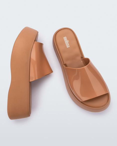 Top and side view of a pair of Melissa Becky platform slides in beige