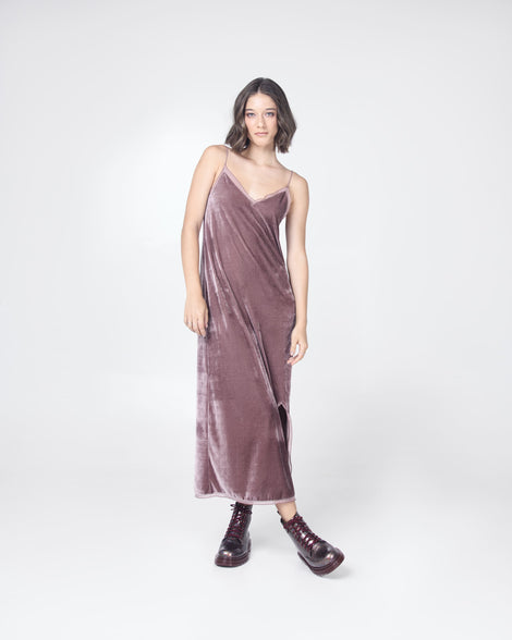 Model in a mauve dress wearing a pair of black/multicolor glitter Melissa Coturno boots.