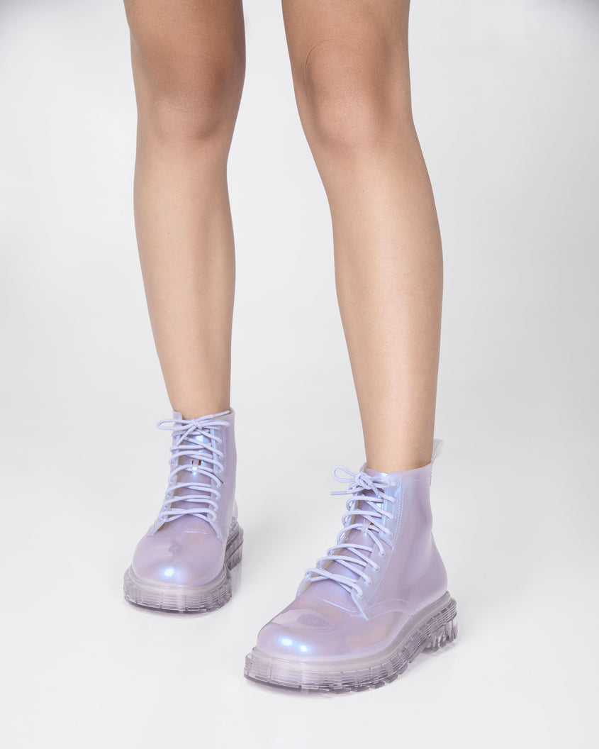 Models legs wearing a pair of pearly lilac Melissa Coturno boots.