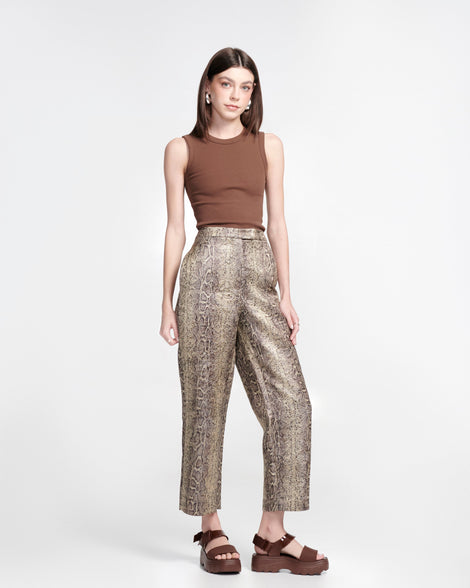 Model in a brown shirt and snake print pants wearing a pair of brown Kick Off Sandals
