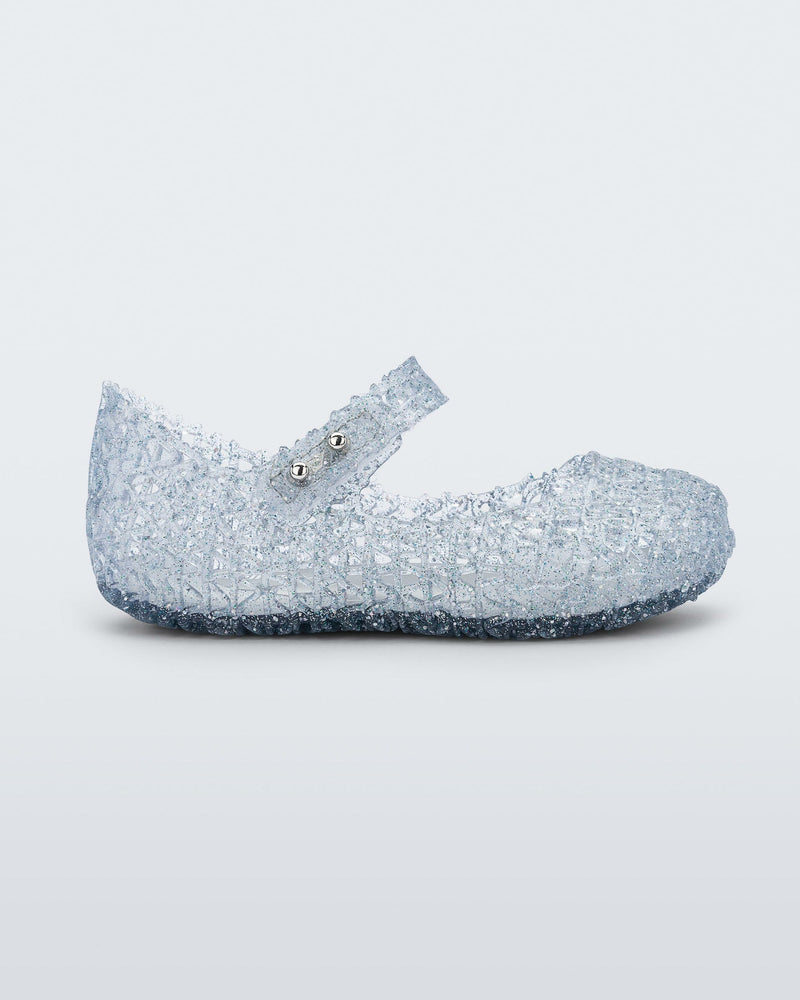 Side view of Mini Melissa Campana clear glitter flats with a snap strap for baby with an open woven texture