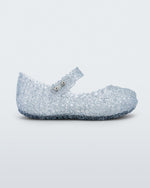 Side view of Mini Melissa Campana clear glitter flats with a snap strap for baby with an open woven texture