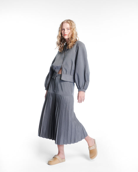 Model in grey skirt with top wearing a pair of beige Cozy Clog Velvet slides