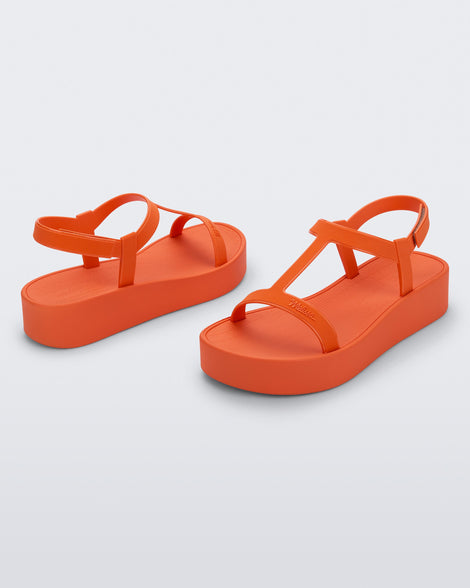 Back and angled view of a pair of orange Sun Capri Platform sandals with ankle straps